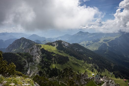 Breathtaking view of lush green alpine mountains under a partly cloudy sky.