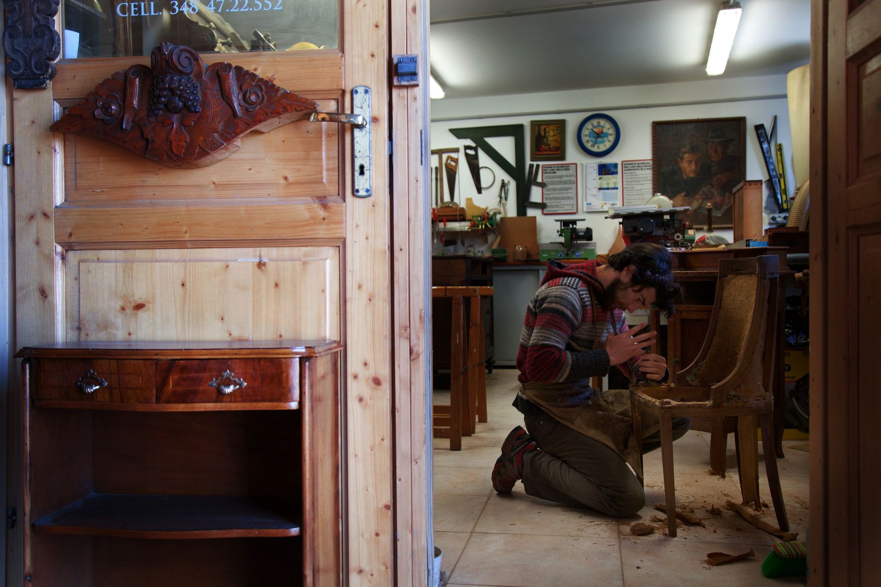 Craftsperson restoring a wooden chair in a furniture workshop