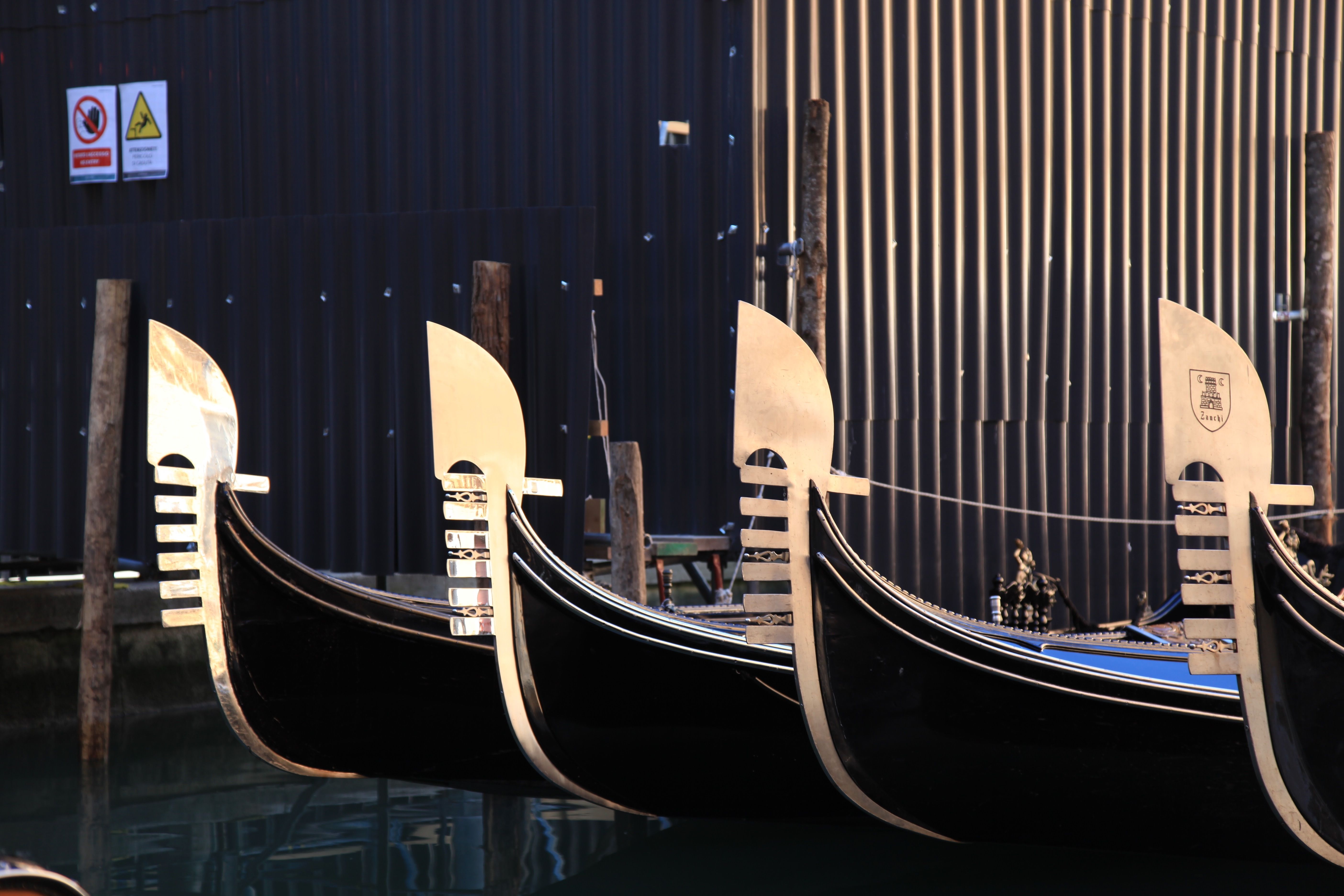 Close-up of gondolas docked along a Venetian canal, capturing their distinctive prows and serene atmosphere.