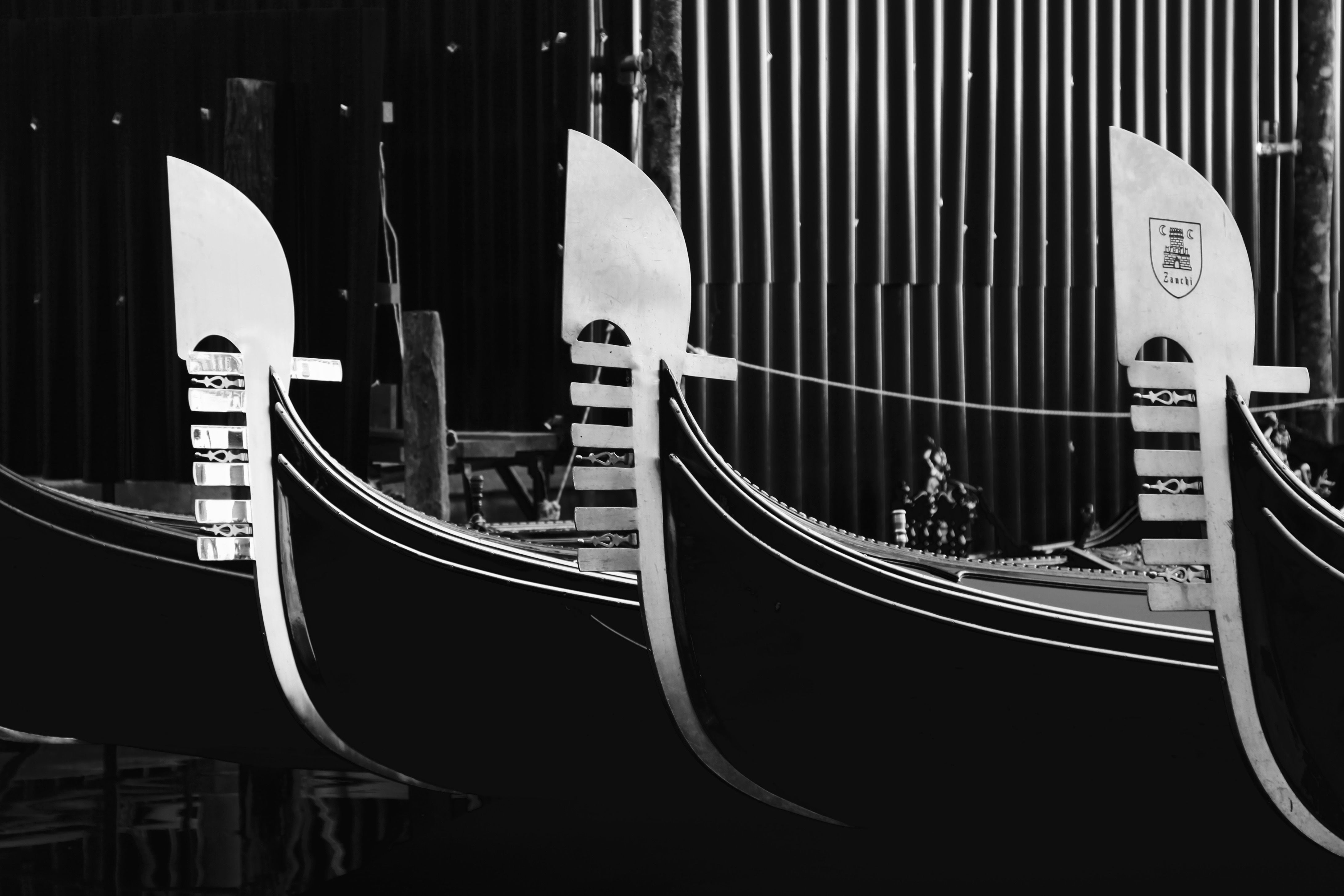 Artistic black and white image of gondolas in Venice, highlighting their elegant design.