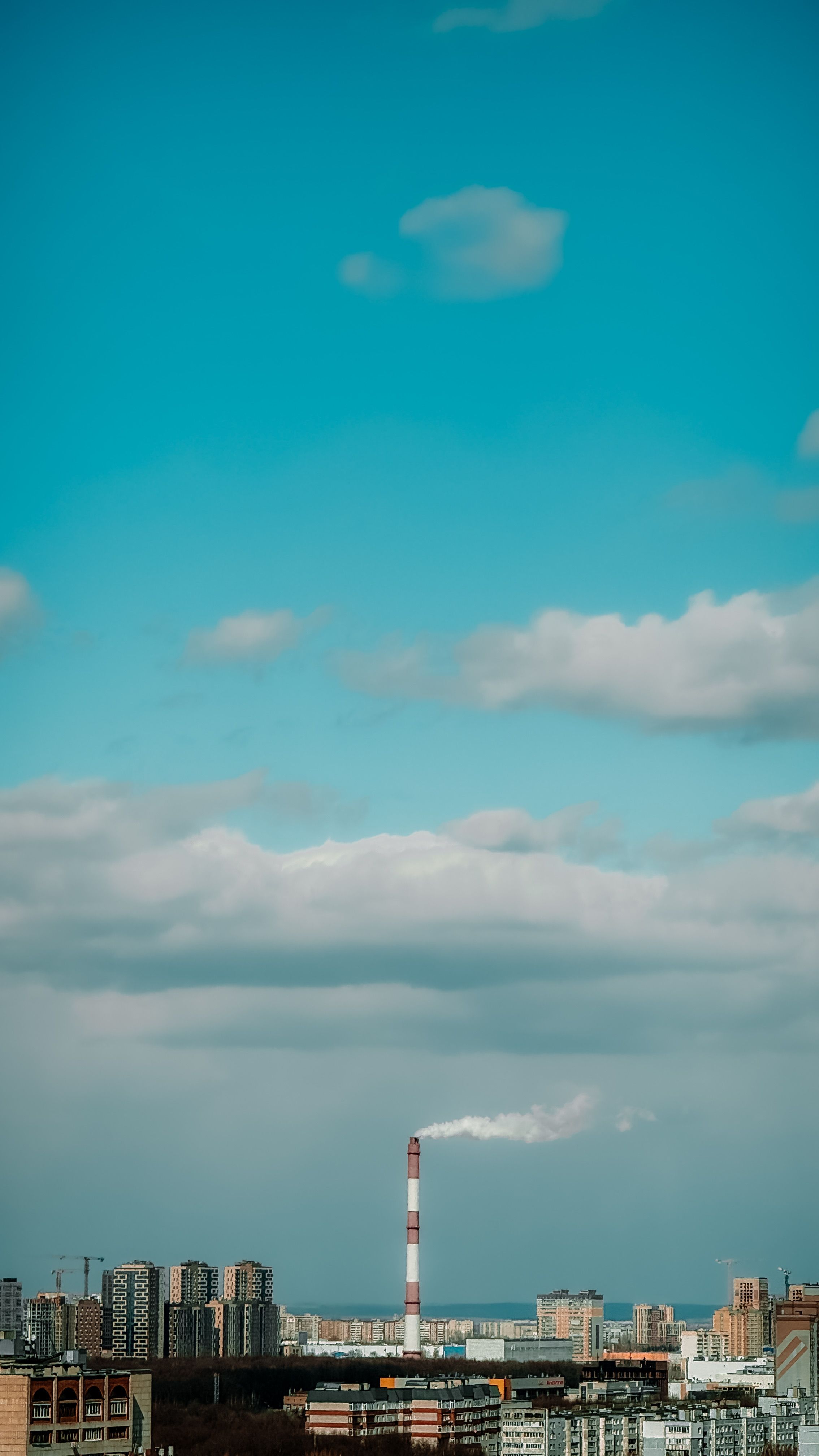 Urban Skyline with Industrial Stack and Clouds · Free Stock Photo