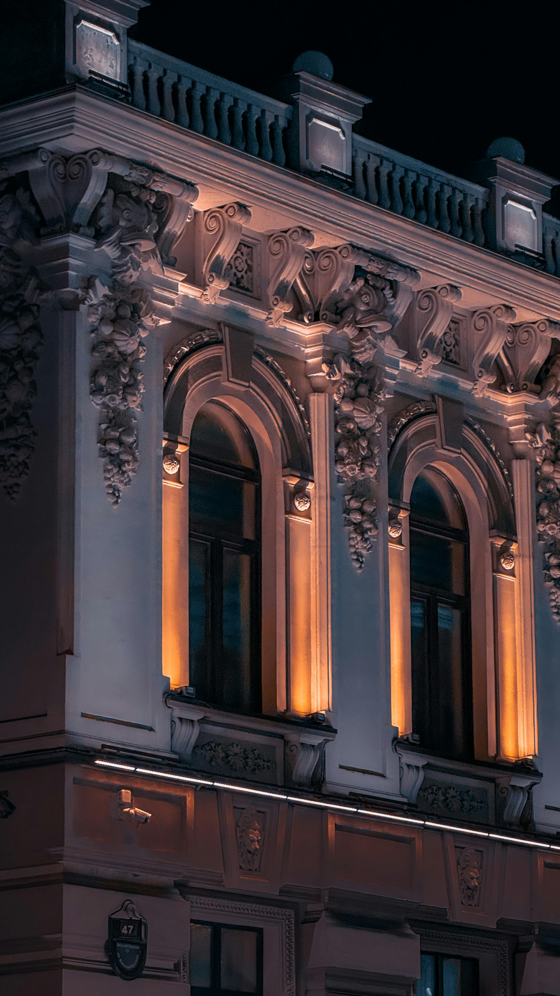 Bezpłatne Pięknie oświetlona nocą barokowa fasada, ukazująca misterne detale architektoniczne. Zdjęcie z galerii