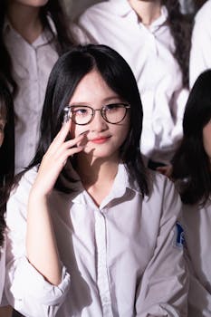 Portrait of a young woman in glasses smiling indoors with a soft light ambiance.