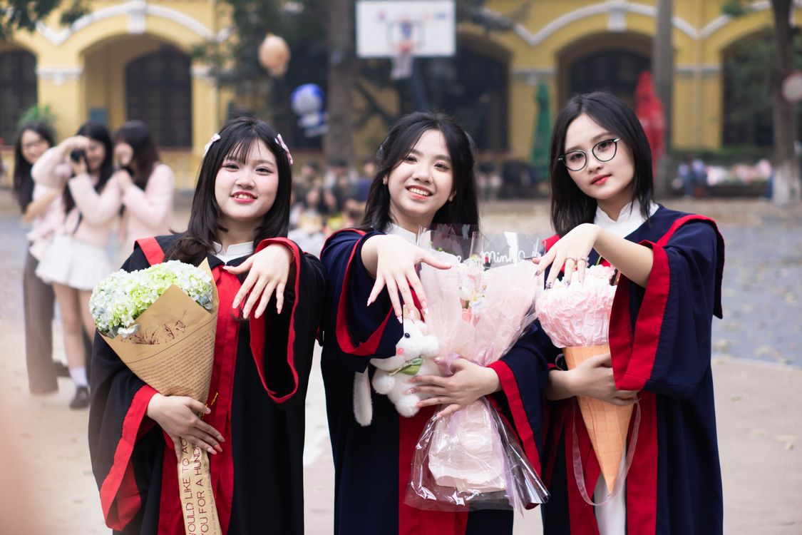 Students in graduation caps and gowns celebrating completing their college degrees
