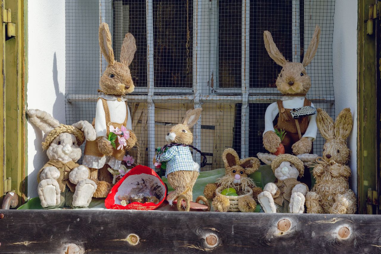 adorable straw bunny figures arranged on a rustic window sill in sprin