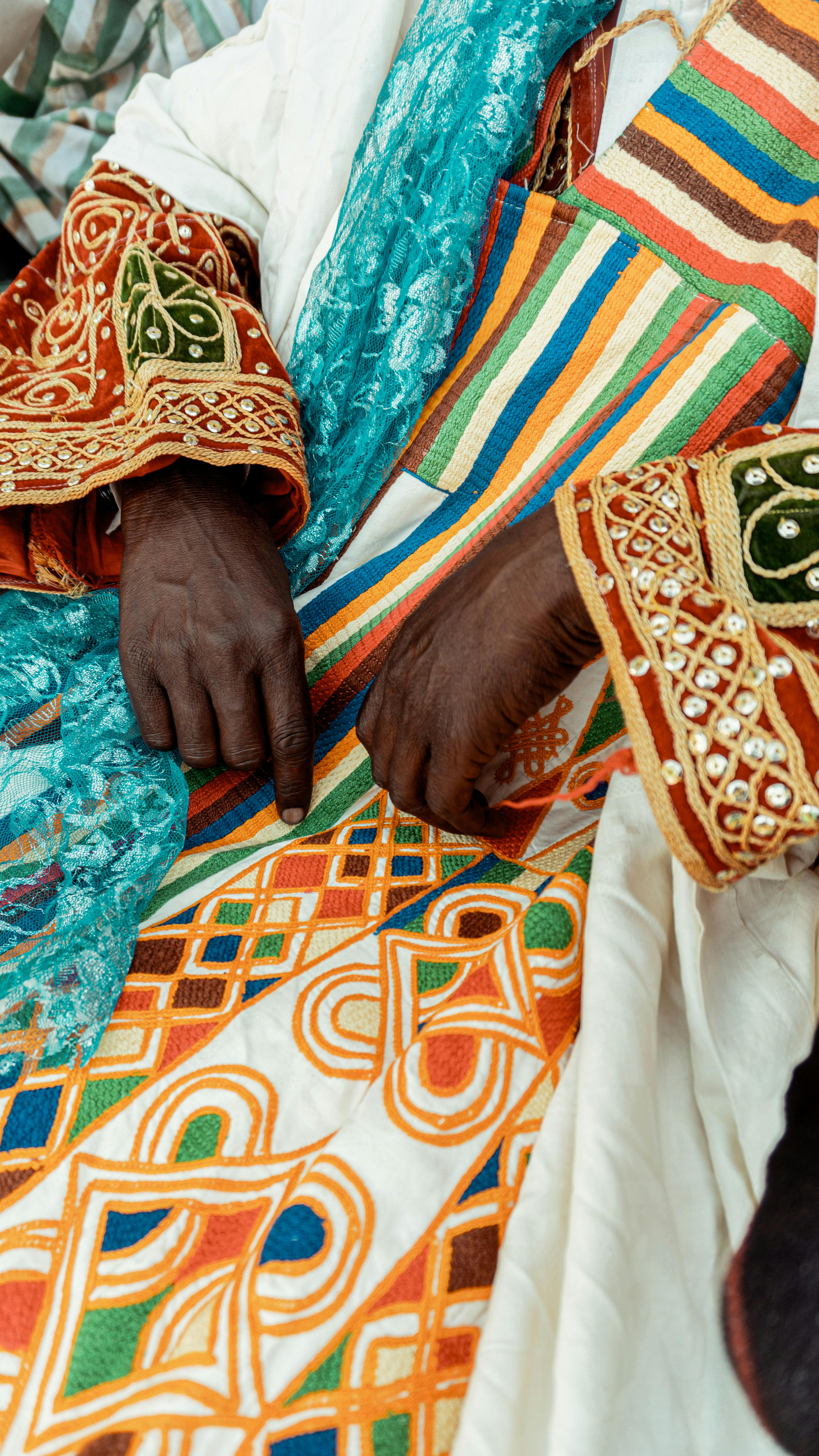 Close-up of intricate and vibrant traditional Nigerian clothing with ornate patterns and embroidery, showing cultural heritage.