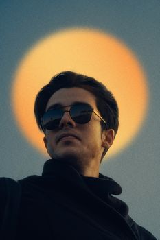 Man wearing sunglasses with a glowing halo effect in the background, creating a modern, artistic look.