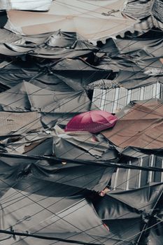 A striking pink umbrella stands out among the monochrome tarpaulin roofs in Ho Chi Minh City, Vietnam.