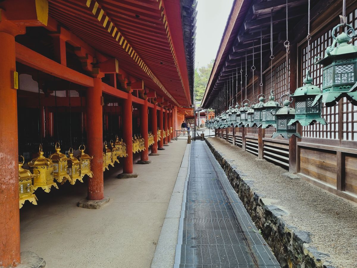 Traditional Japanese temple with stone lanterns and red pillars in Nara