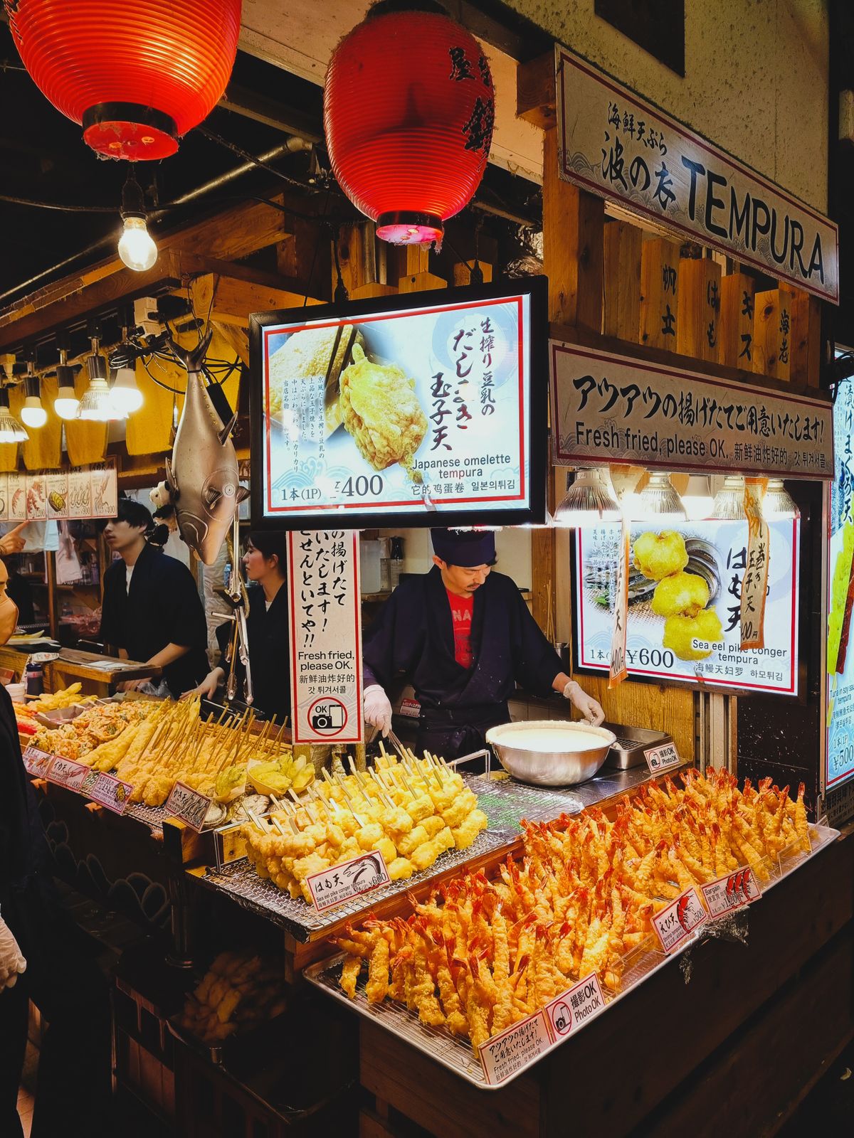 Bustling Japanese street market with a tempura and prepared food display