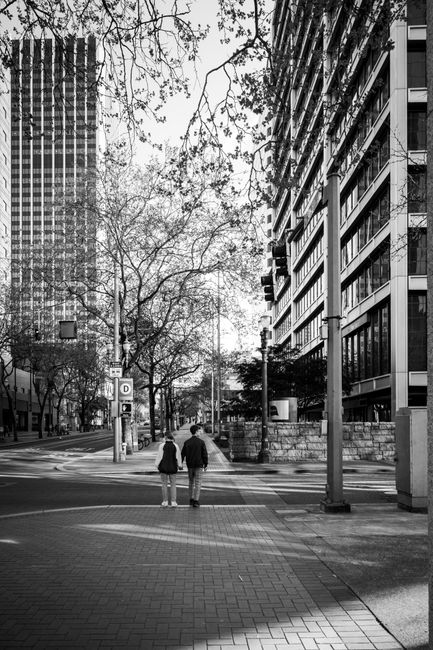 Monochrome street view of Portland, Oregon with two people walking downtown.