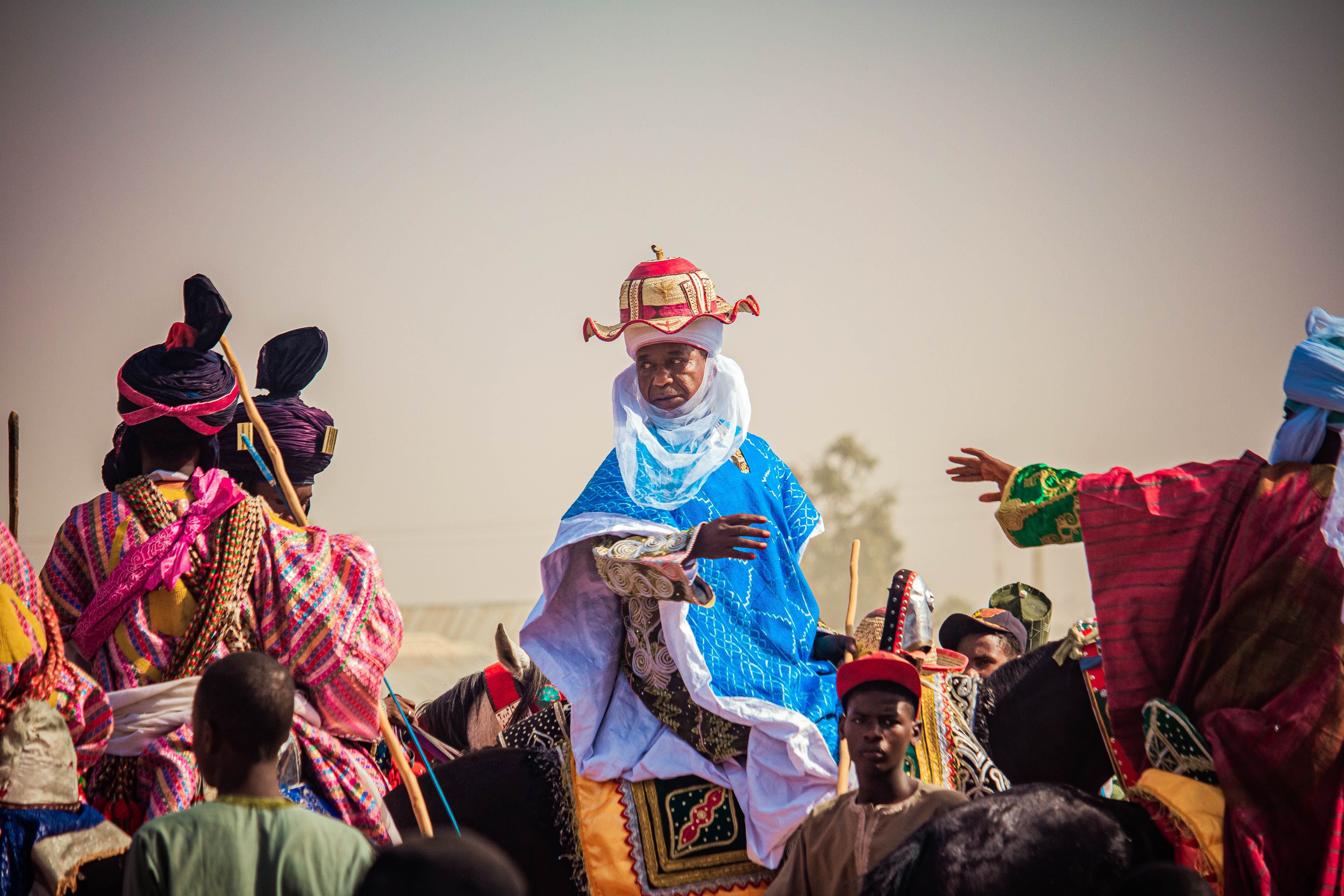 Colorful traditional ceremony in Nigeria featuring riders in vibrant attire.