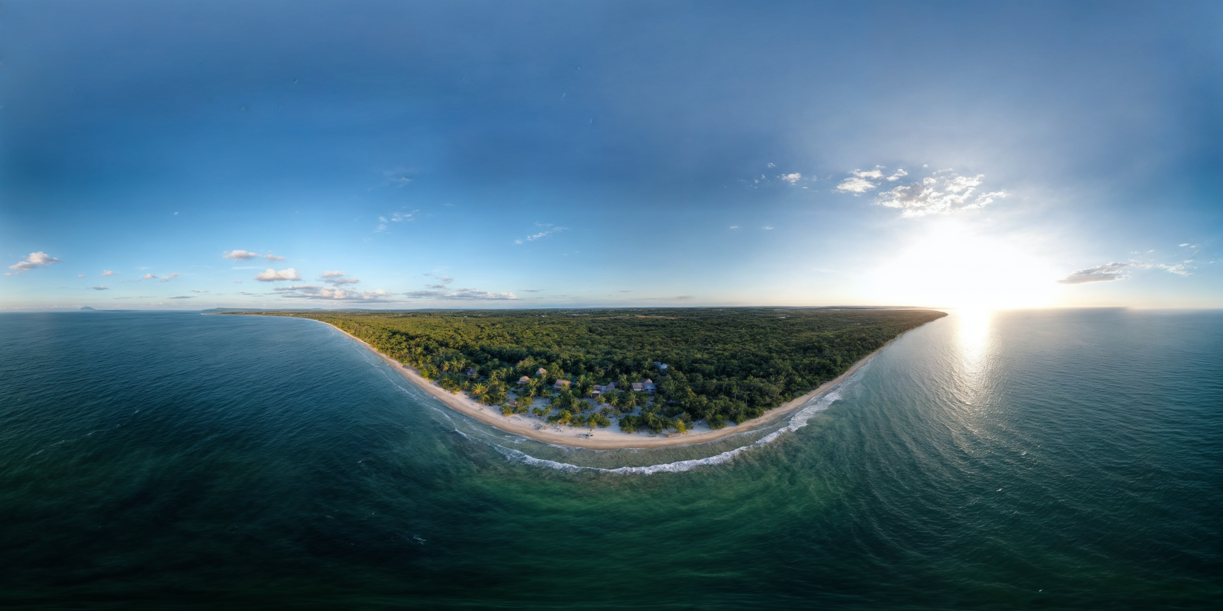 Stunning aerial view of Santa Marta beach and coastline lit by sunrise, with tranquil ocean waves.