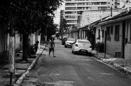Free Black and white urban street scene in Praia Grande, São Paulo, featuring people and cars. Stock Photo
