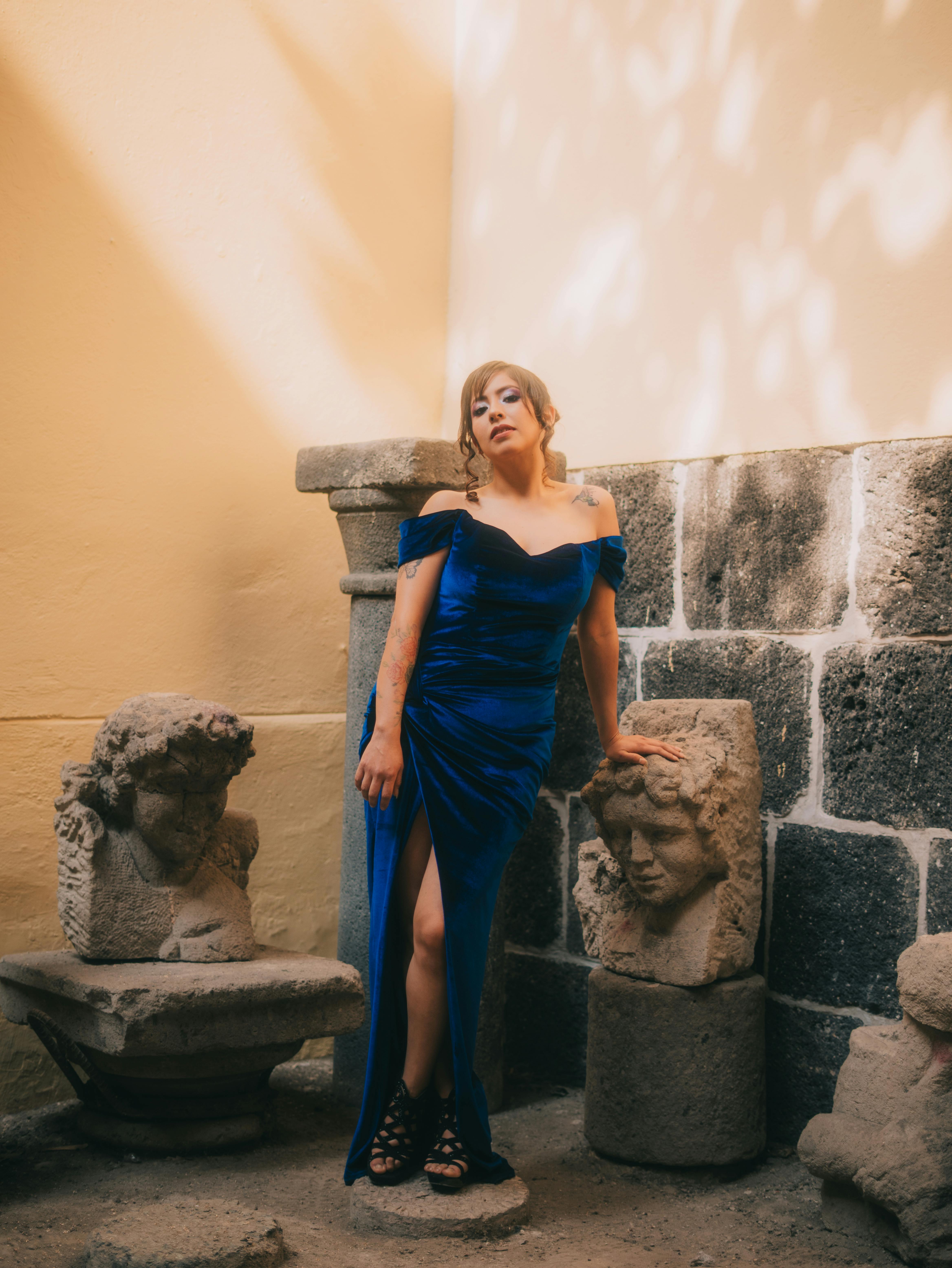 gratis Een model in een blauwe jurk poseert sierlijk bij eeuwenoude sculpturen in een museum in Mexico-Stad. Stockfoto