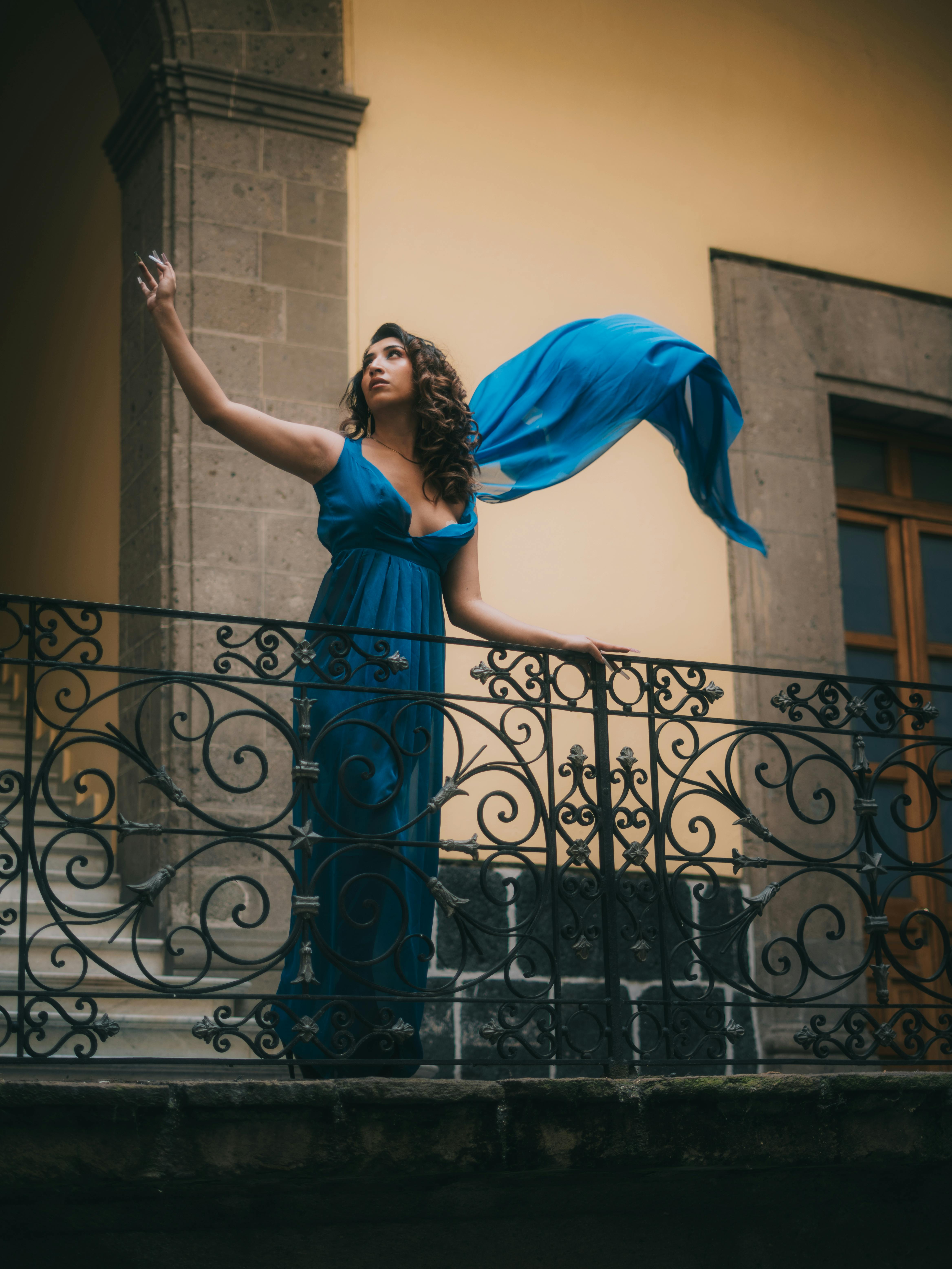 Gratis Wanita elegan dengan gaun biru berkibar berpose di balkon bersejarah di Mexico City. Foto Stok
