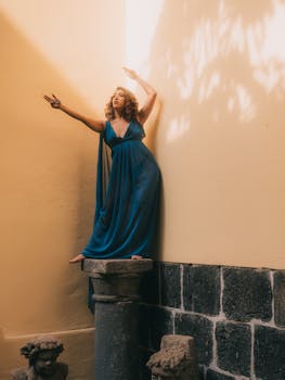 Elegant fashion model posing in a blue dress in a historic setting in Mexico City.