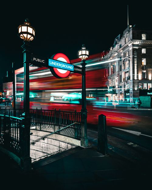 Free Vibrant night scene of an iconic London Underground entrance with blurred light trails. Stock Photo