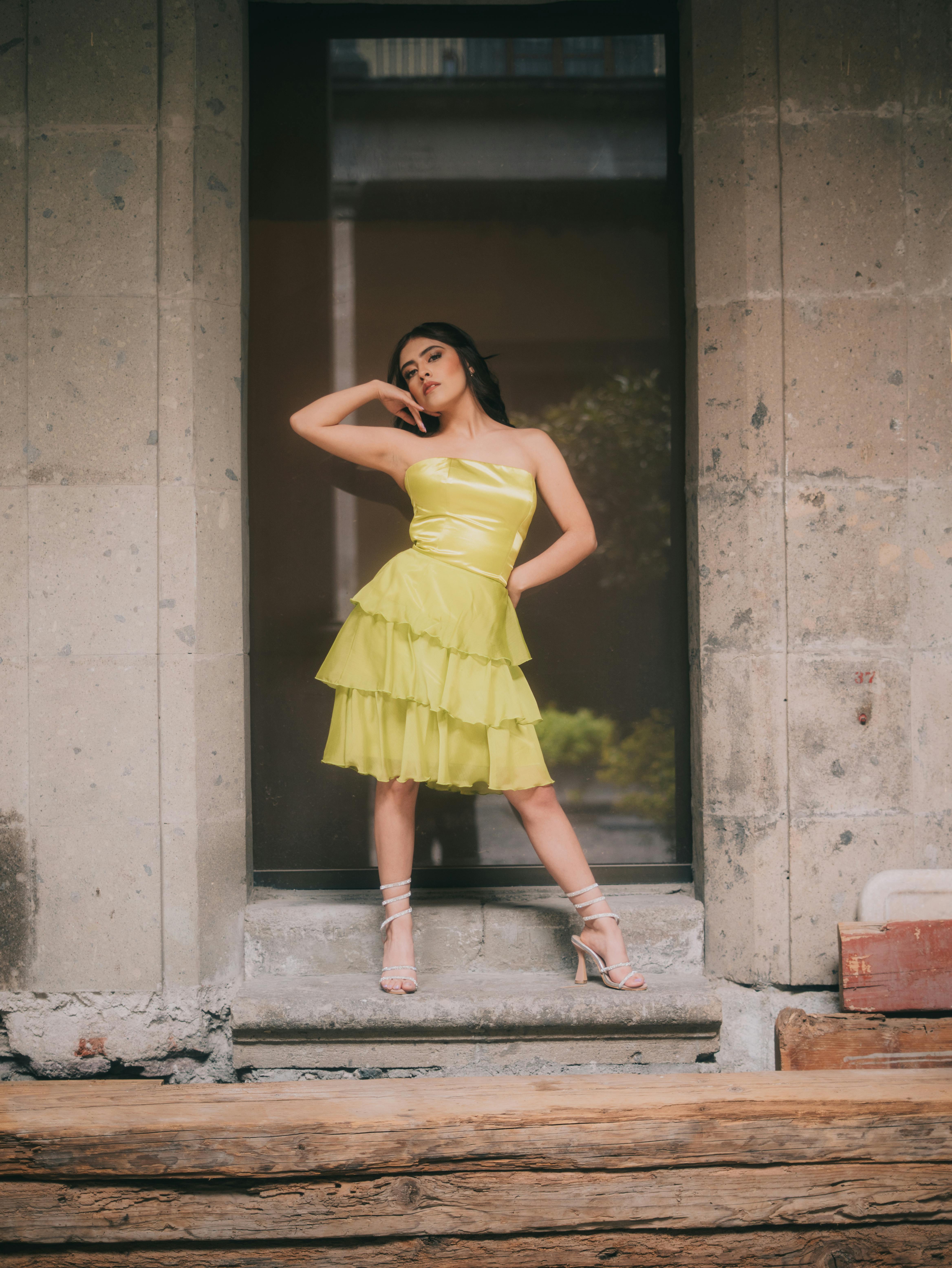 Gratis Una modella posa con un vivace abito verde lime su uno sfondo rustico a Città del Messico. Foto a disposizione