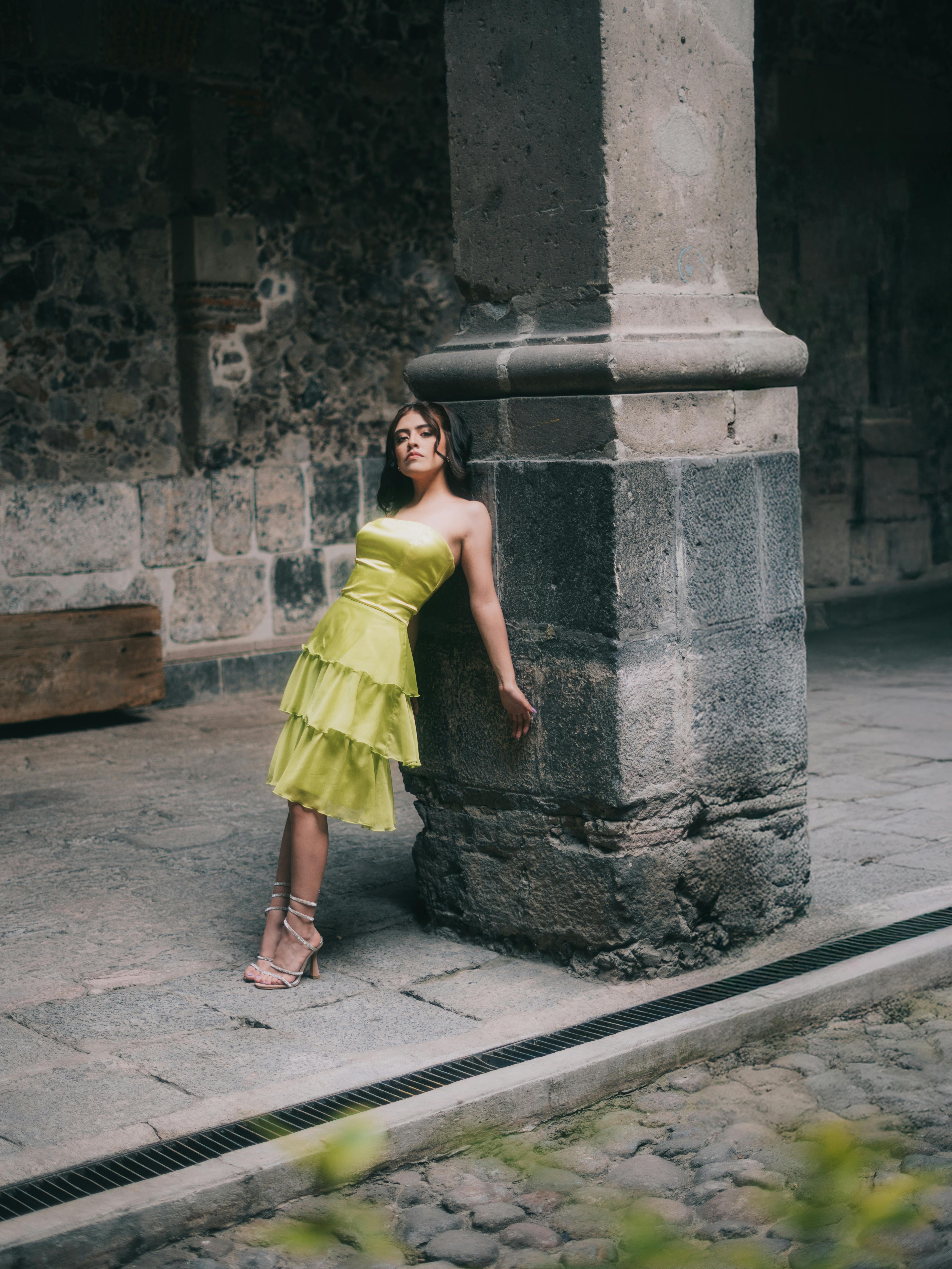 Gratuit Femeie elegantă în rochie verde, sprijinită de stâlpul istoric de piatră din Mexico City. Fotografie de stoc