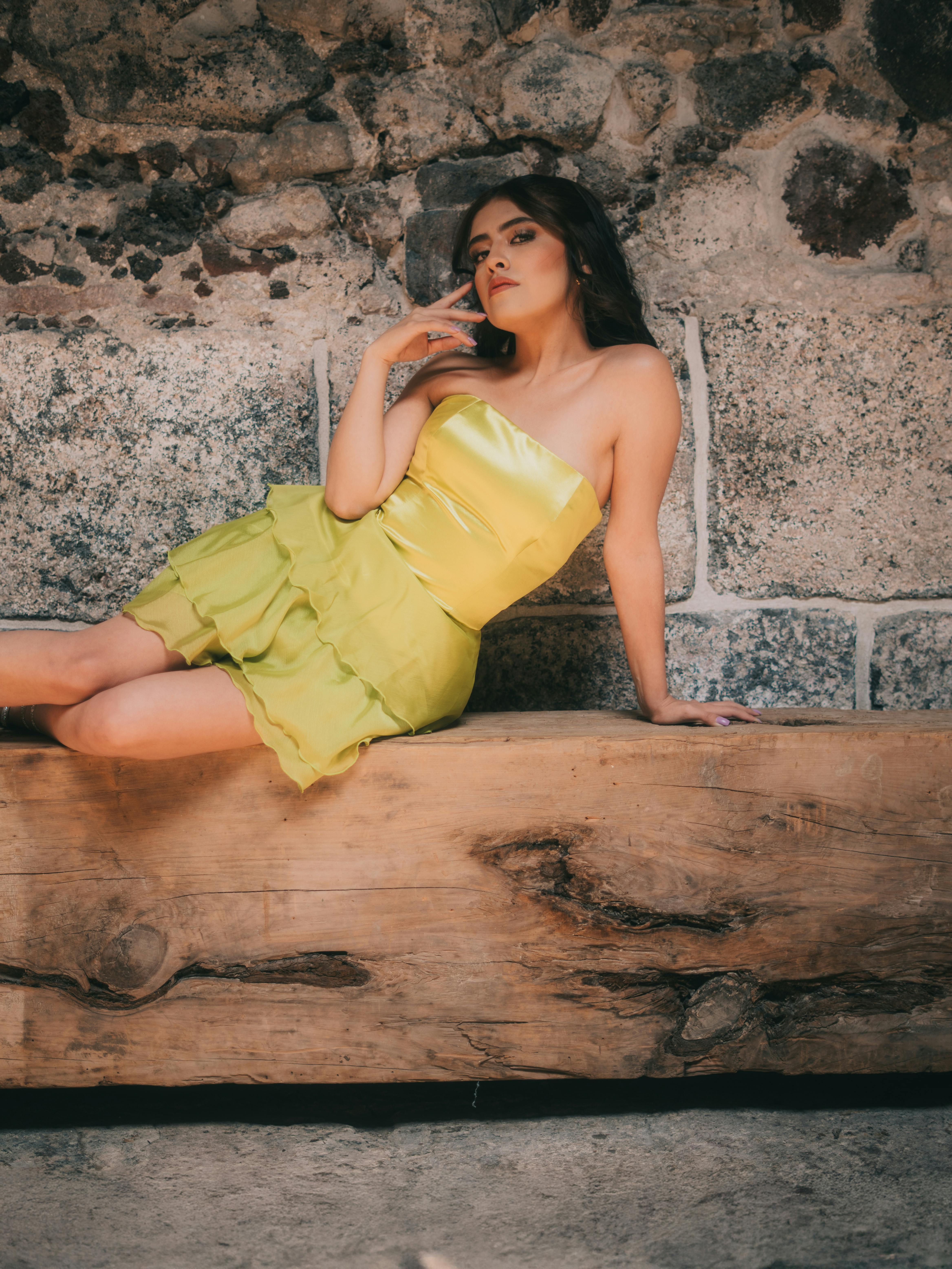 Gratuit Model de modă care pozează într-o rochie verde lime lângă un zid de piatră, emanând eleganță și farmec. Fotografie de stoc