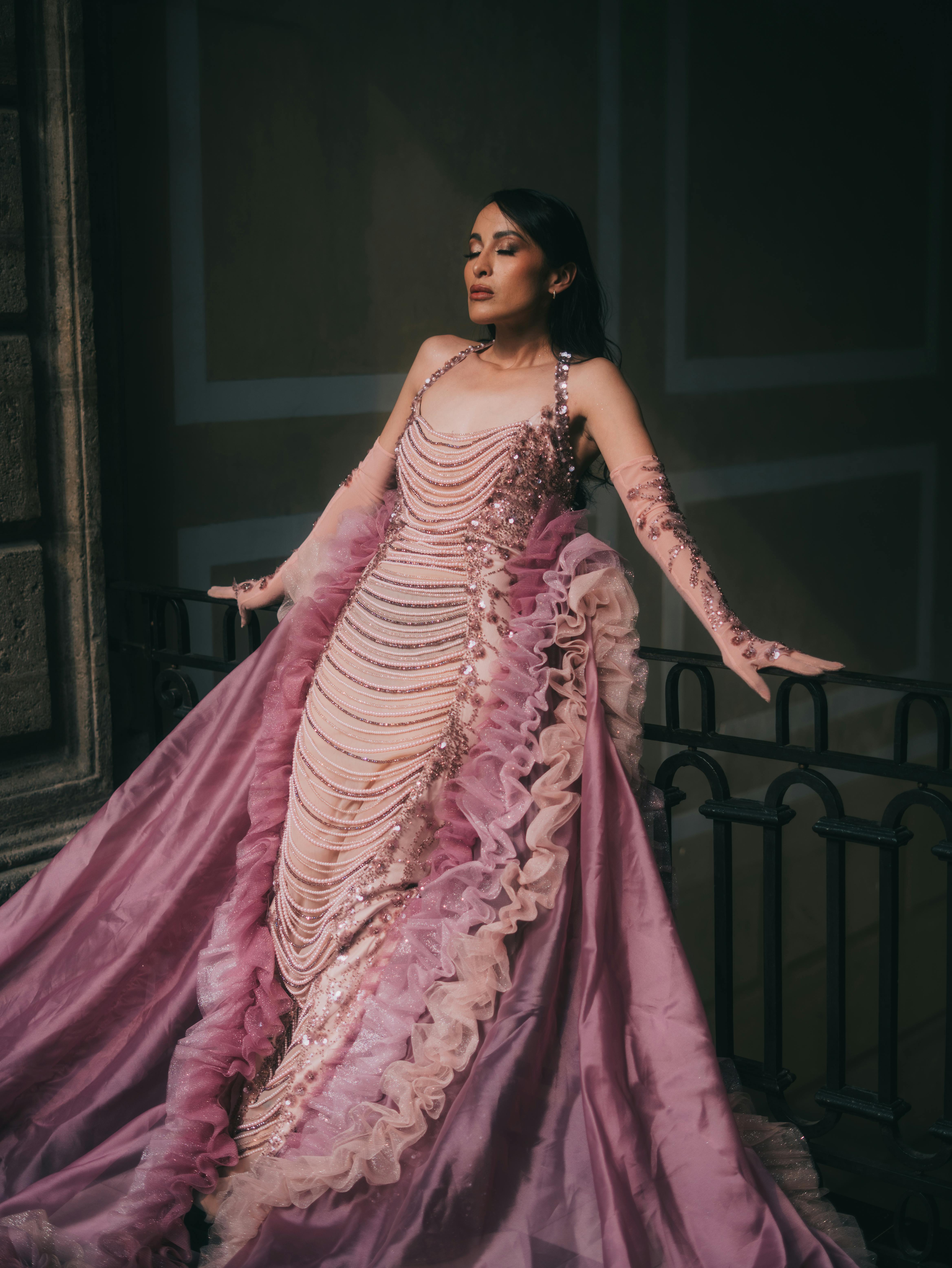 Gratis Una modella in un abito splendido posa elegantemente su uno sfondo storico. Foto a disposizione