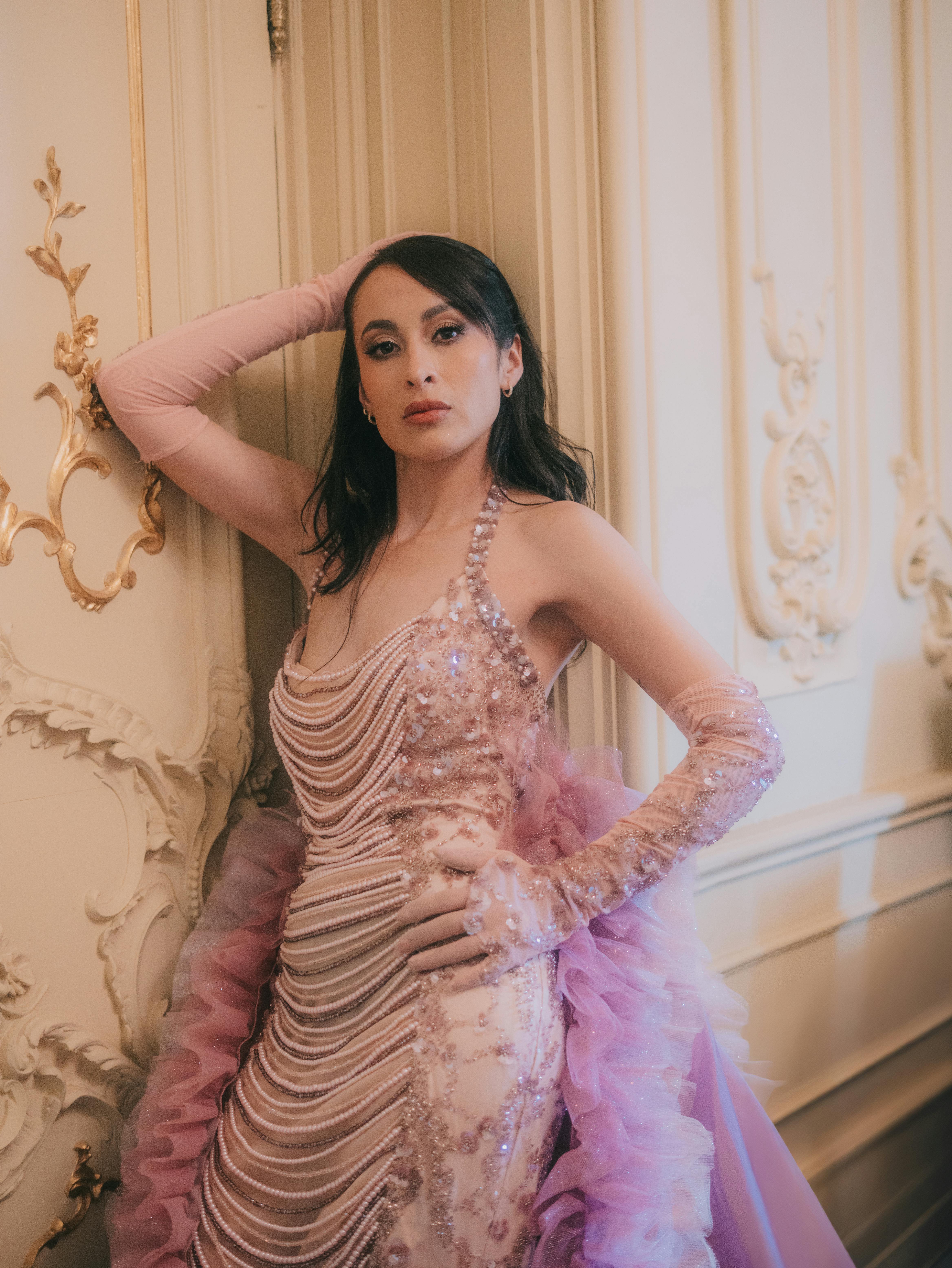 gratis Een modemodel poseert sierlijk in een sierlijk interieur, gekleed in een roze couturejurk. Stockfoto