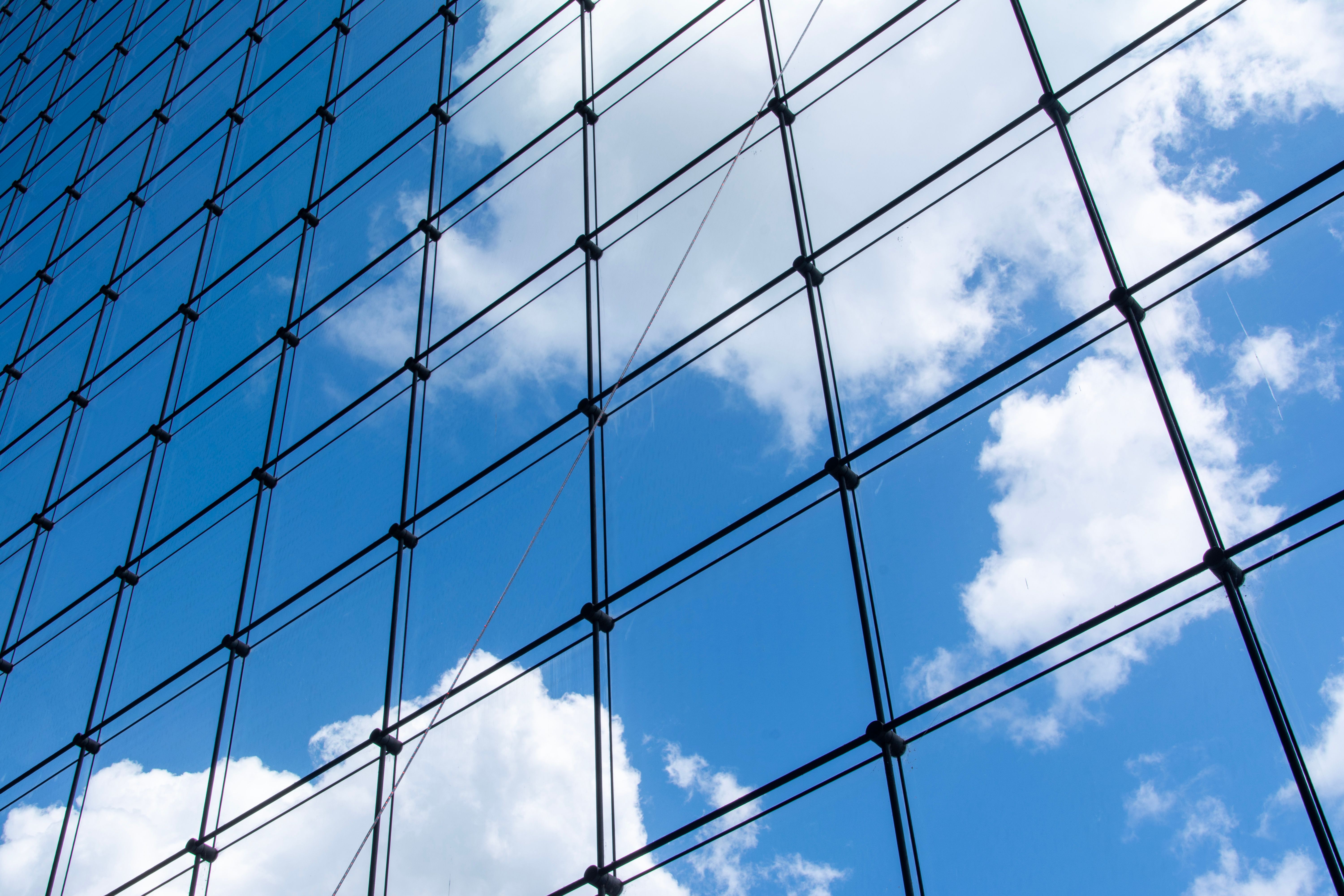Modern Glass Facade Reflecting Blue Sky · Free Stock Photo