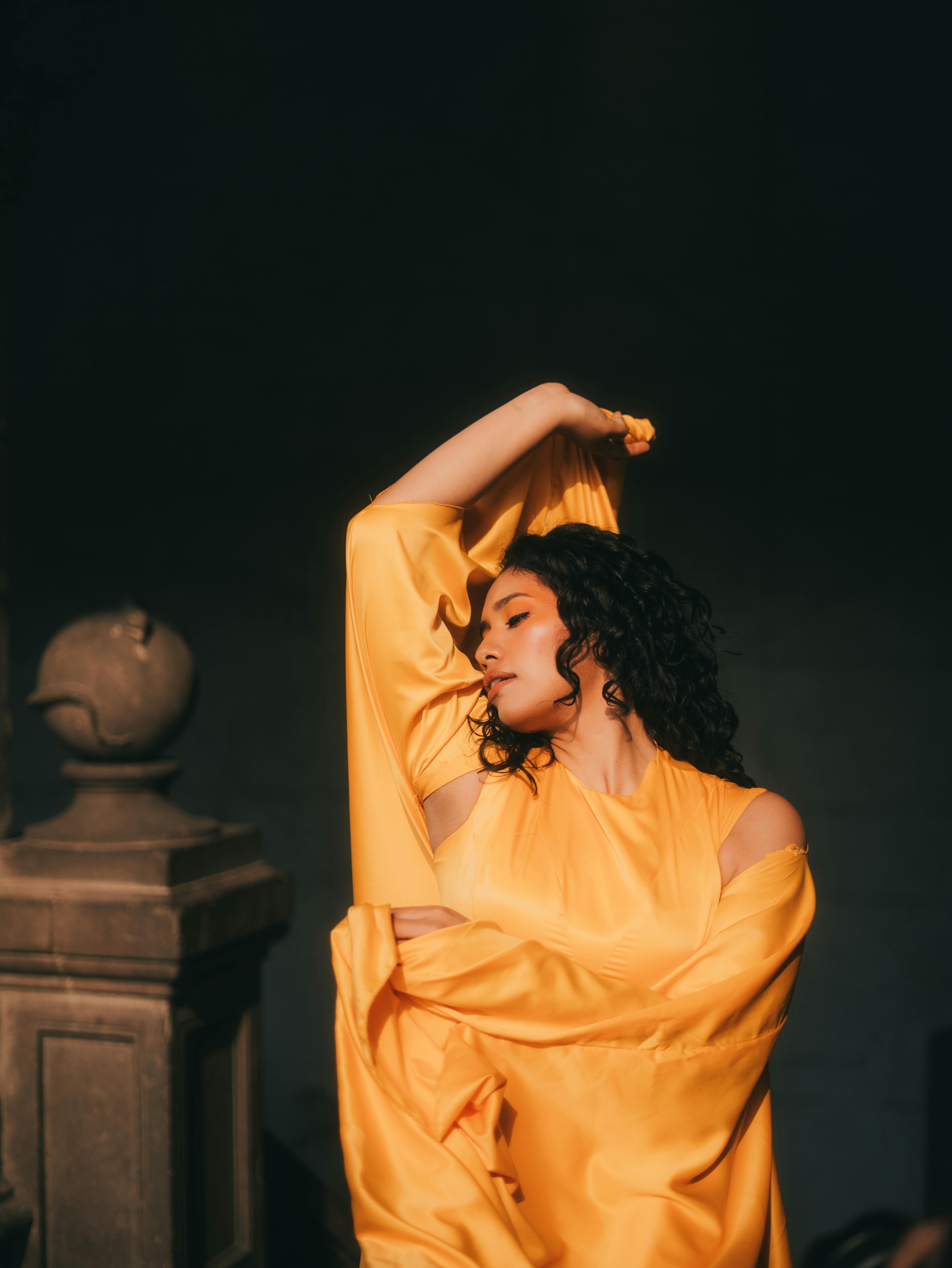 Gratis Pose mencolok seorang model fesyen dalam gaun kuning yang berkibar, Kota Meksiko Foto Stok