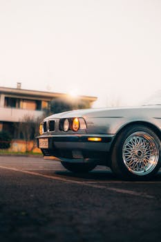 Vintage car parked outdoors with warm lighting at sunset, showcasing retro design.