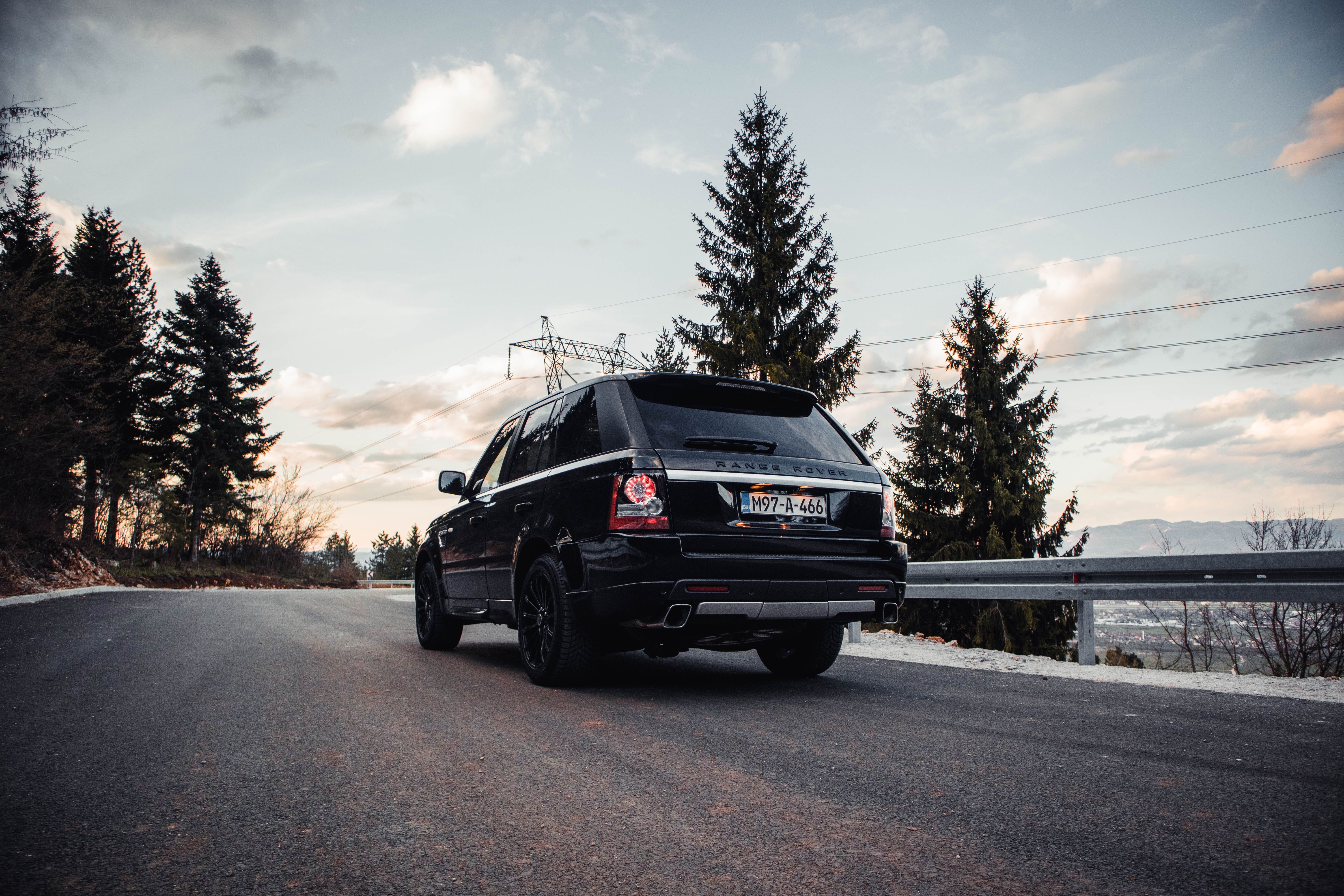 Elegant Range Rover SUV navigating a scenic highland road at golden hour