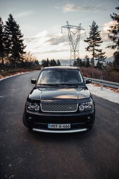 Experience the adventure of driving a Range Rover on a winding mountain road at sunset in Sarajevo.