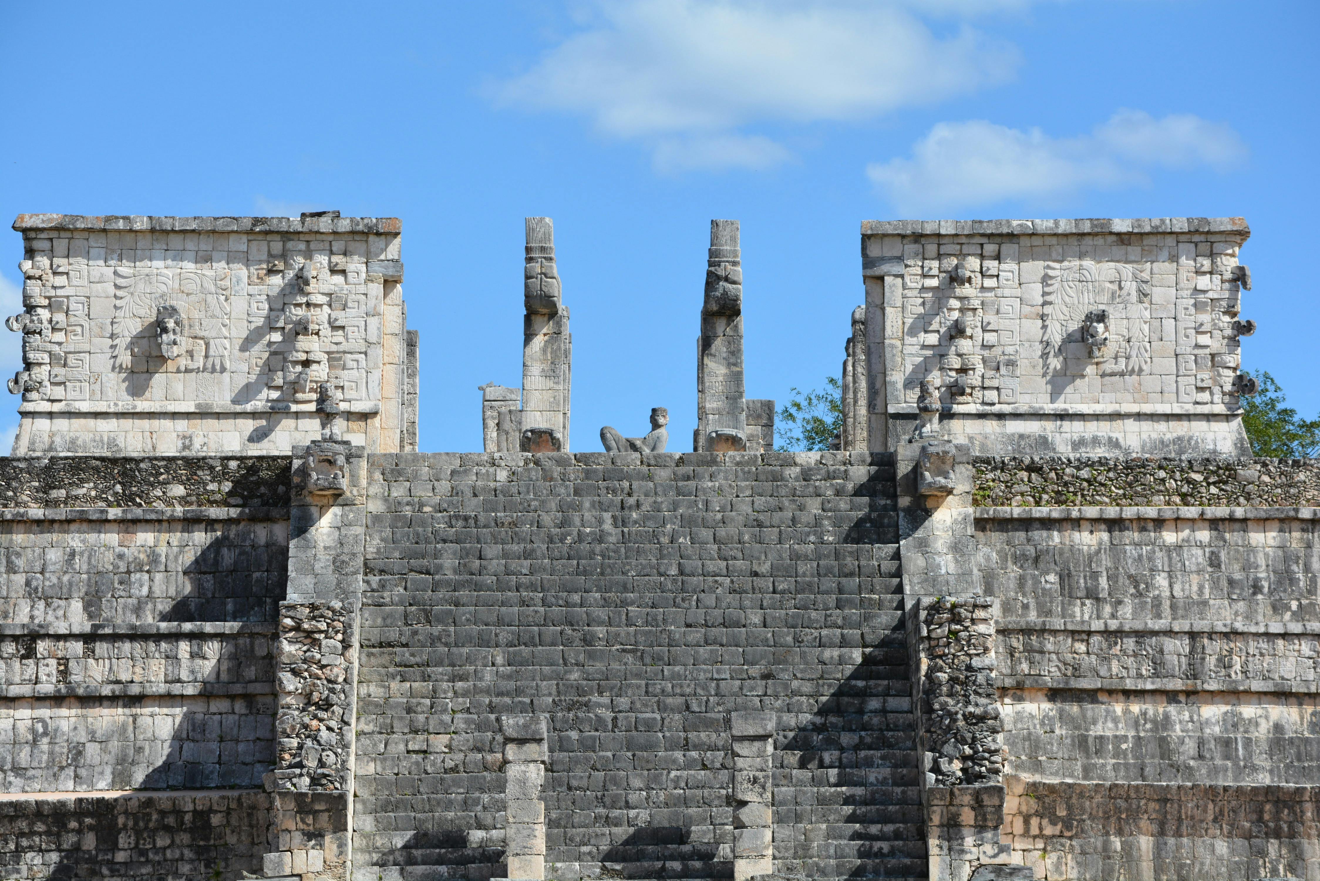 ancient mayan civilization historical tour packages for agencies - Explore the ancient Mayan temple at Chichen Itza showcasing detailed stone carvings under a clear blue sky.