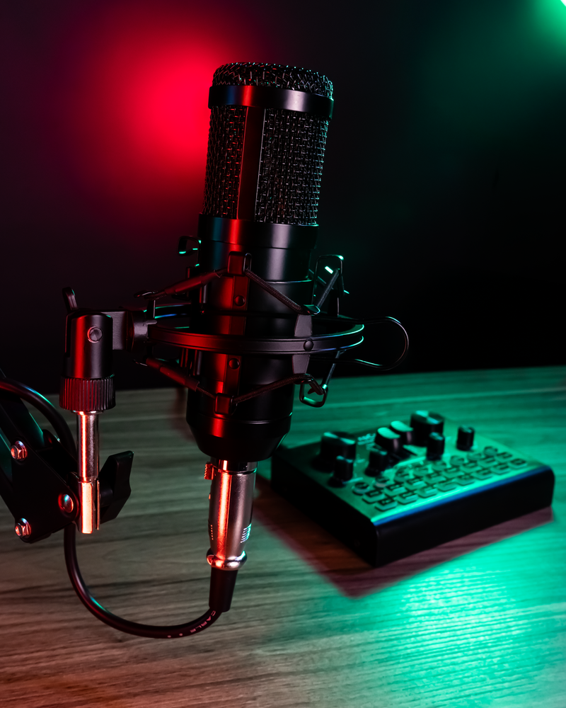 Microfone sobre mesa de podcast com fundo colorido desfocado