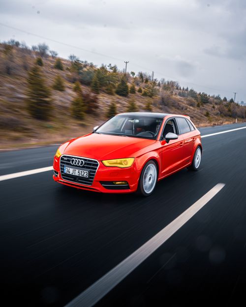Free Red Audi A3 driving on a scenic road in Ankara, Türkiye under cloudy skies. Stock Photo