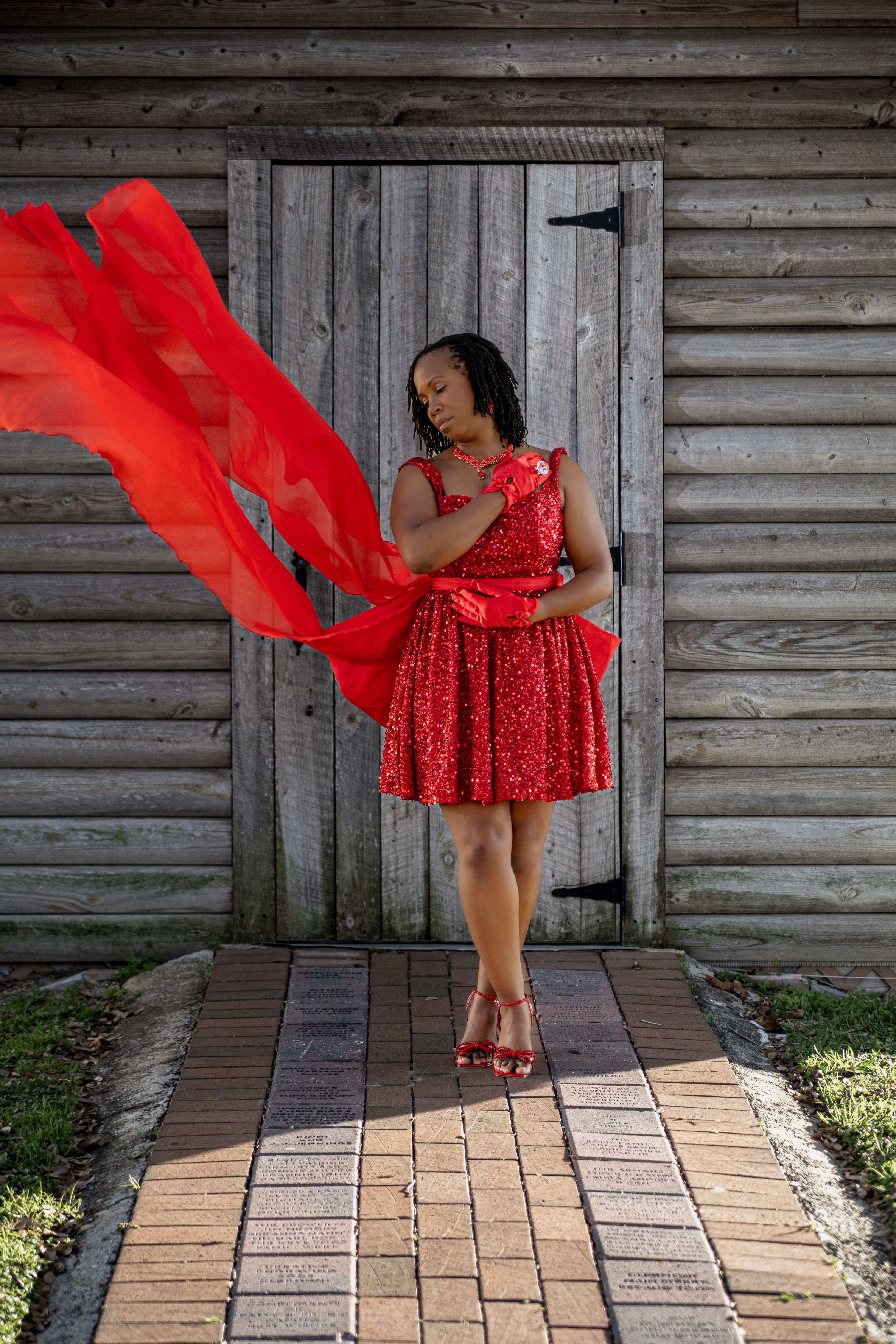 Woman in Red Dress Posing Outdoors with Flowing Fabric · Free Stock Photo