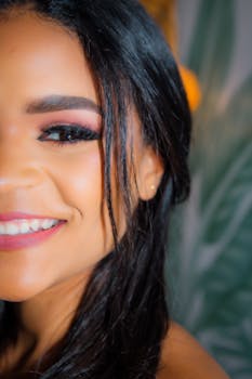 A vibrant close-up of a smiling woman with lush greenery in the background, highlighting beauty and happiness.