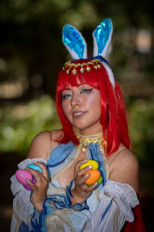 Free Portrait of a woman in cosplay with bunny ears holding colorful Easter eggs. Stock Photo