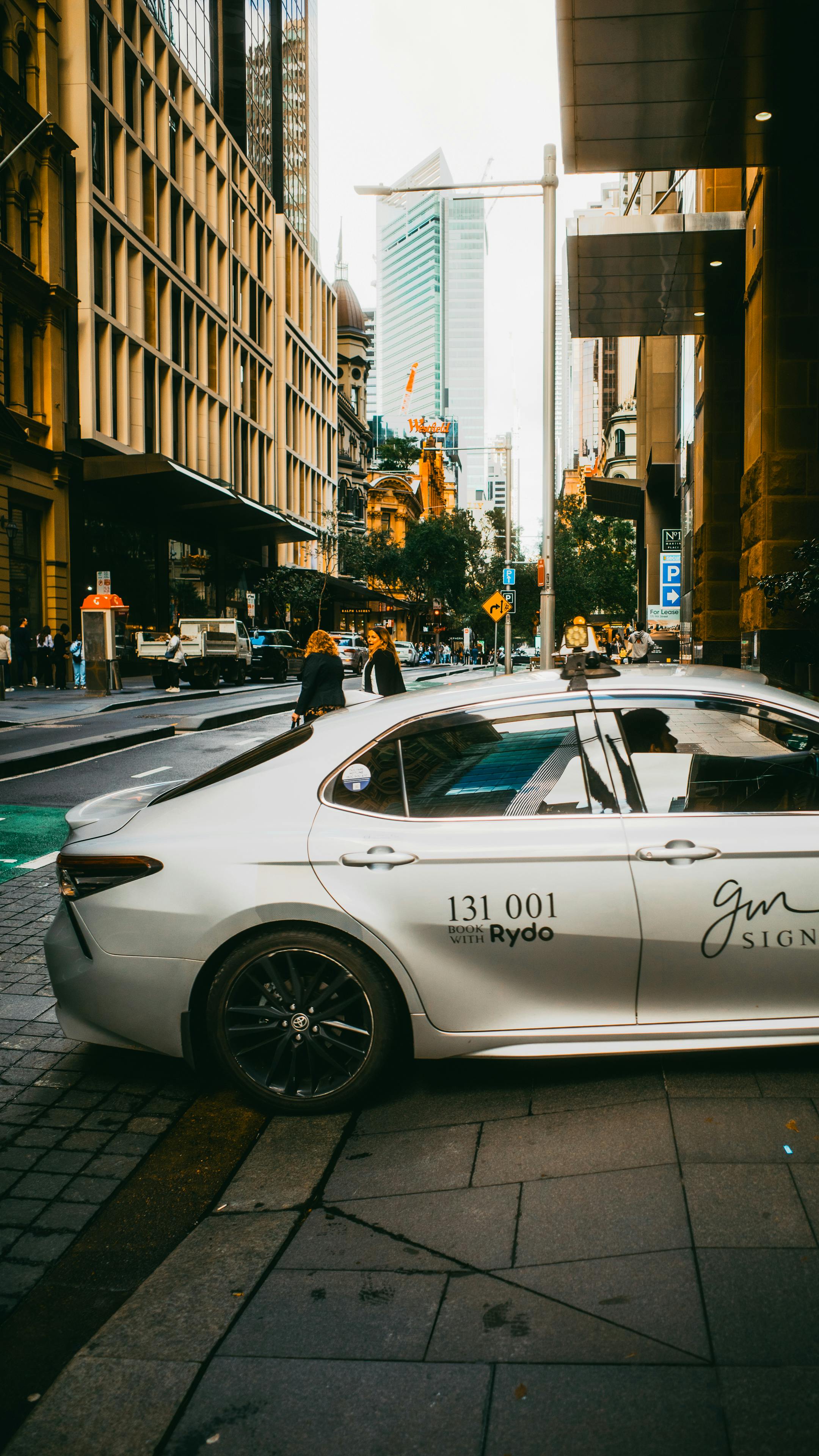 Dynamic street view in Sydney's urban area featuring a parked car and bustling cityscape.