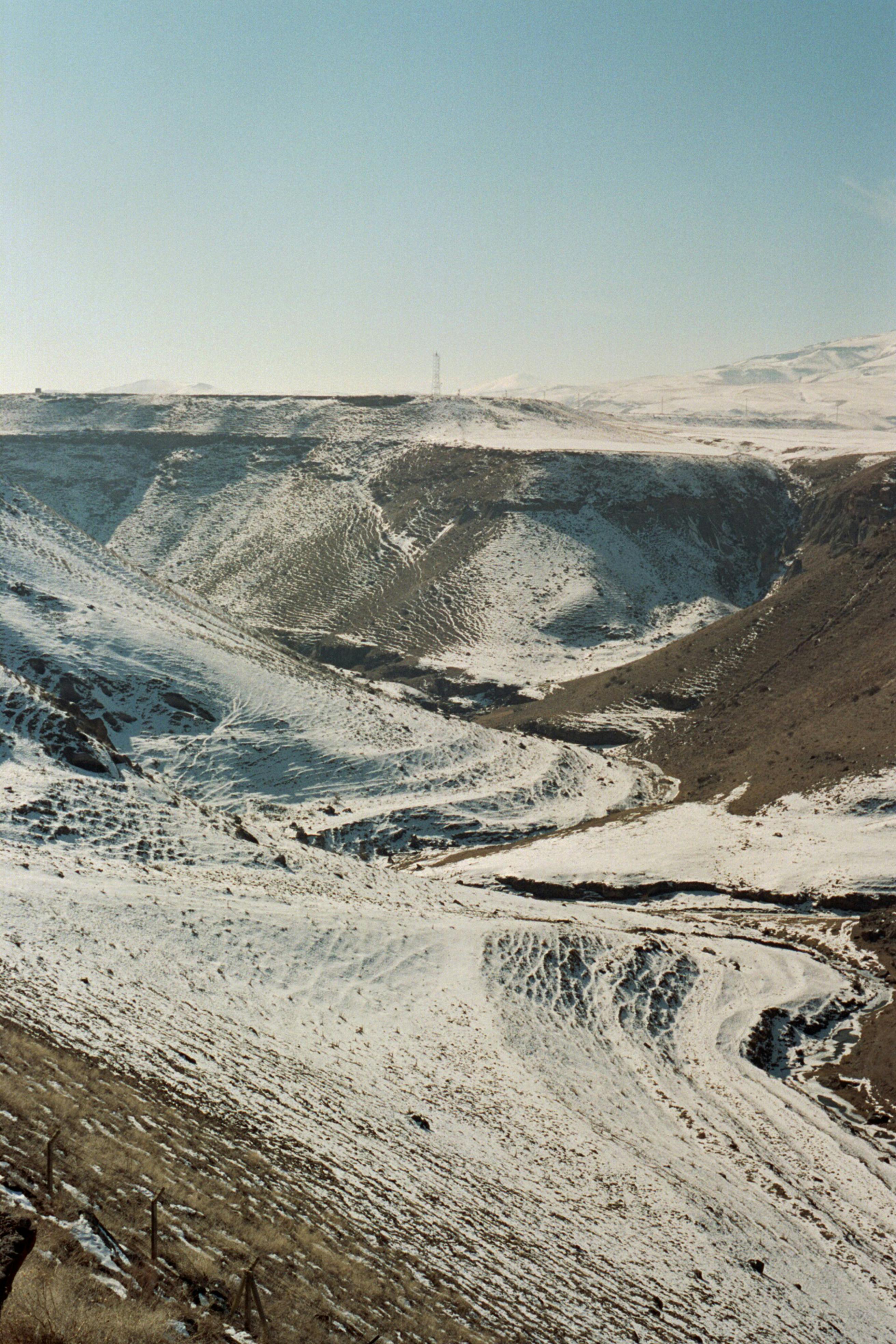 Snow-covered hills and valleys create a serene winter scene in Kars, Türkiye.