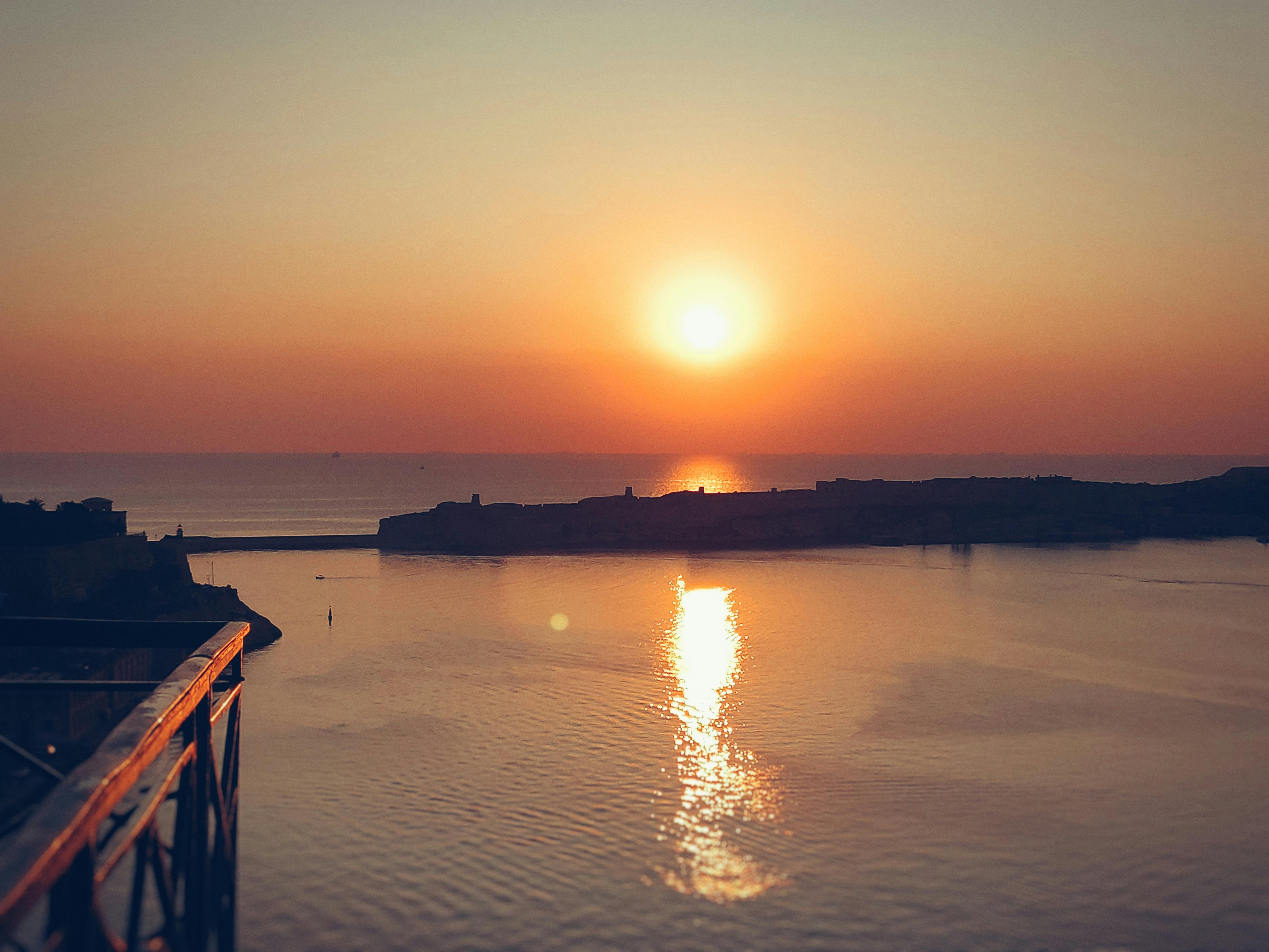 瓦莱塔大港日落景色壮丽，温暖的色调映照在海面上
