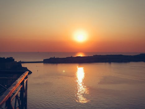 瓦莱塔大港日落景色壮丽，温暖的色调映照在海面上