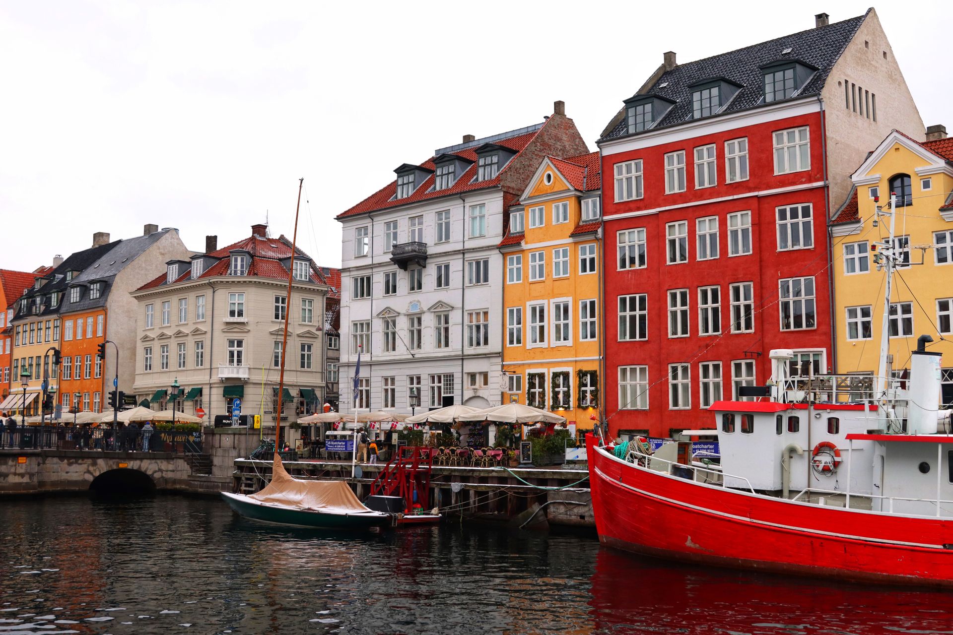 Vibrant buildings and docked boats at Nyhavn Canal, Copenhagen, showcasing Danish architecture and charm.