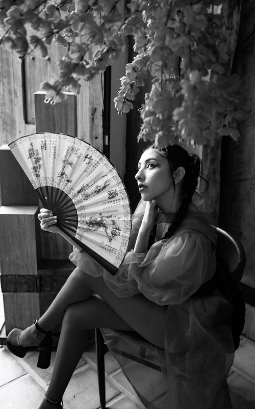 Free Black and white portrait of a woman holding a traditional folding fan. Stock Photo