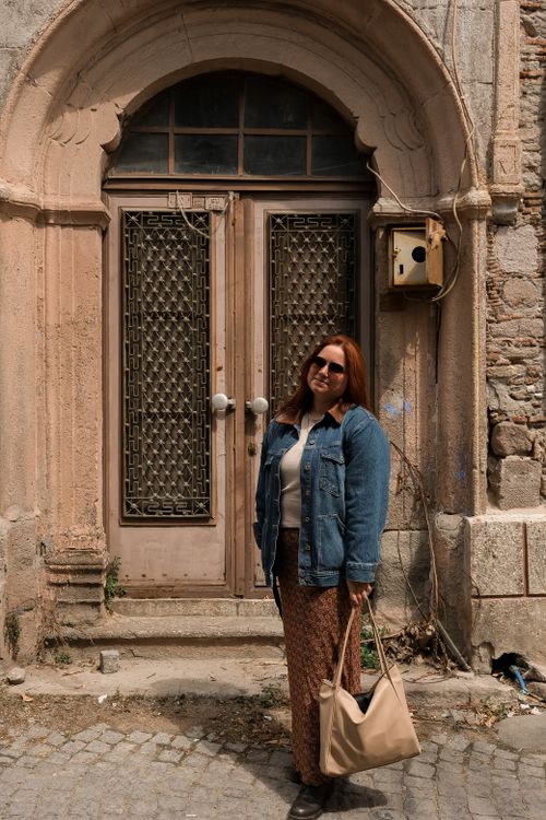 Free A woman poses in front of a historic doorway in Bergama, İzmir. Stock Photo