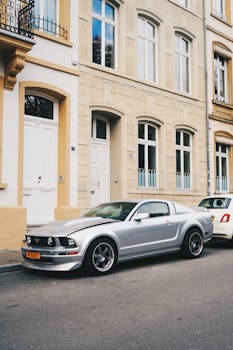 A sleek silver sports car parked on a charming European street with classic architecture.