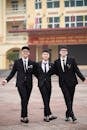 Three Friends in Suits Walking Outdoors