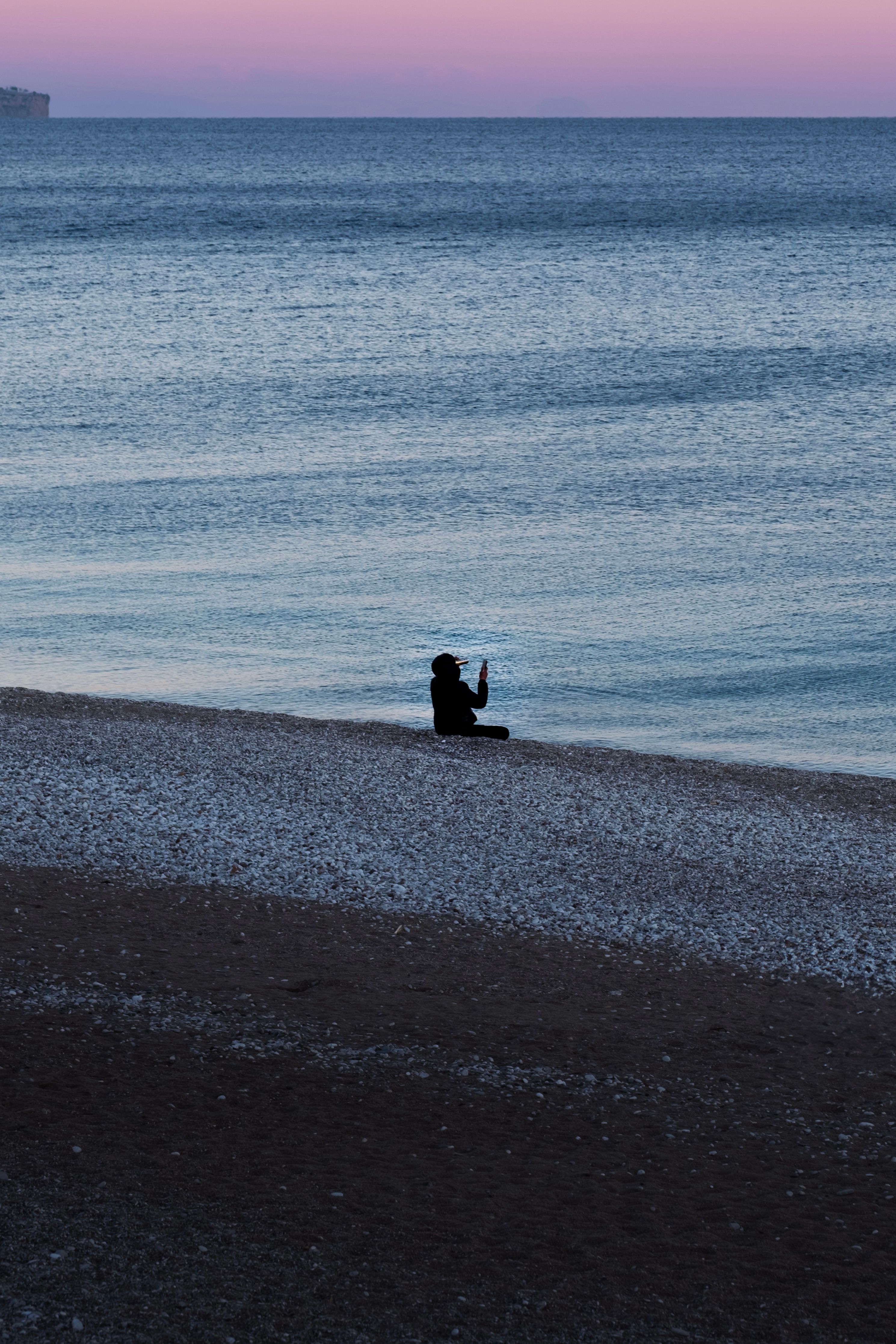 Silhouette of Person Meditating on a Tranquil Beach at Twilight · Free ...
