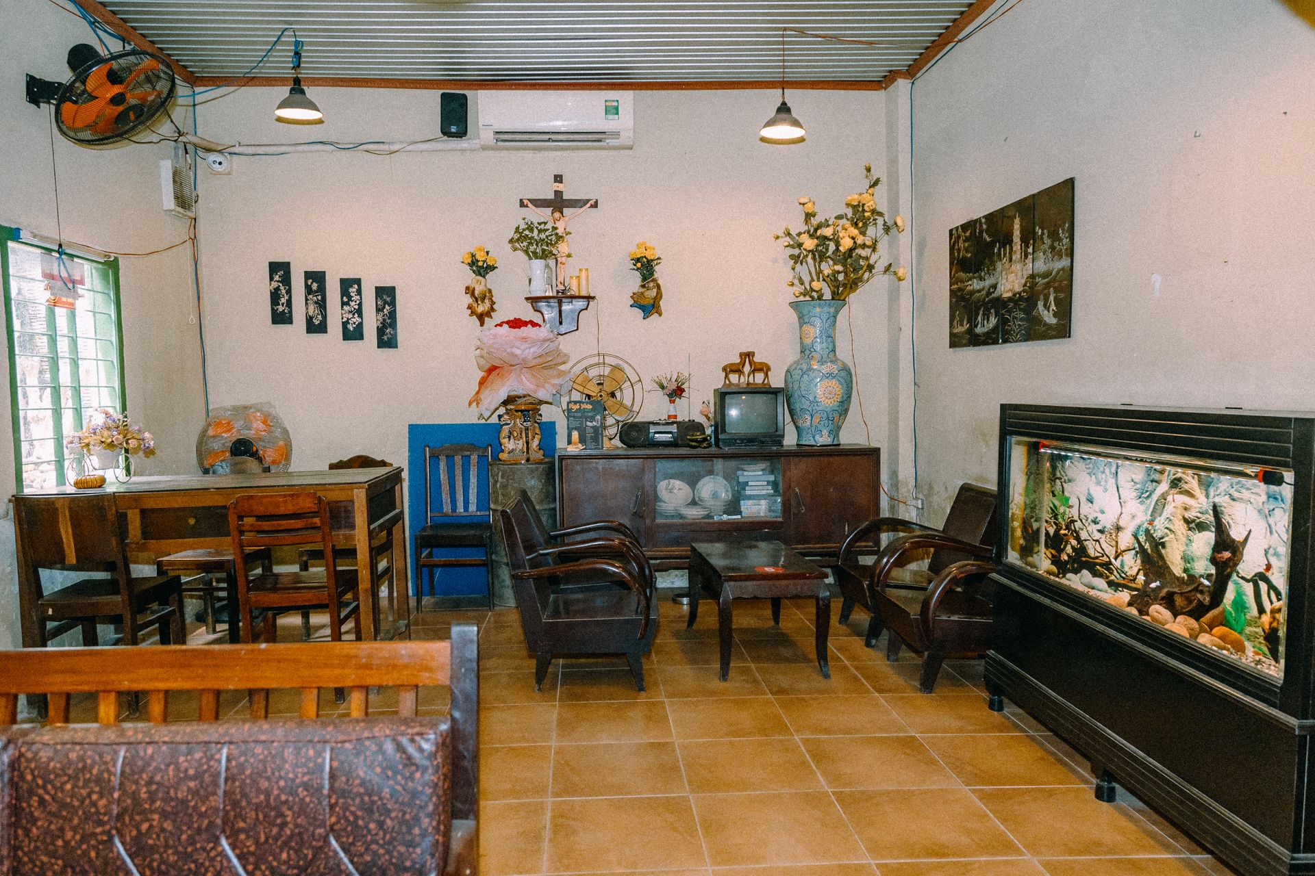 Charming vintage living room with a cozy setup, featuring an aquarium and quaint decor elements.