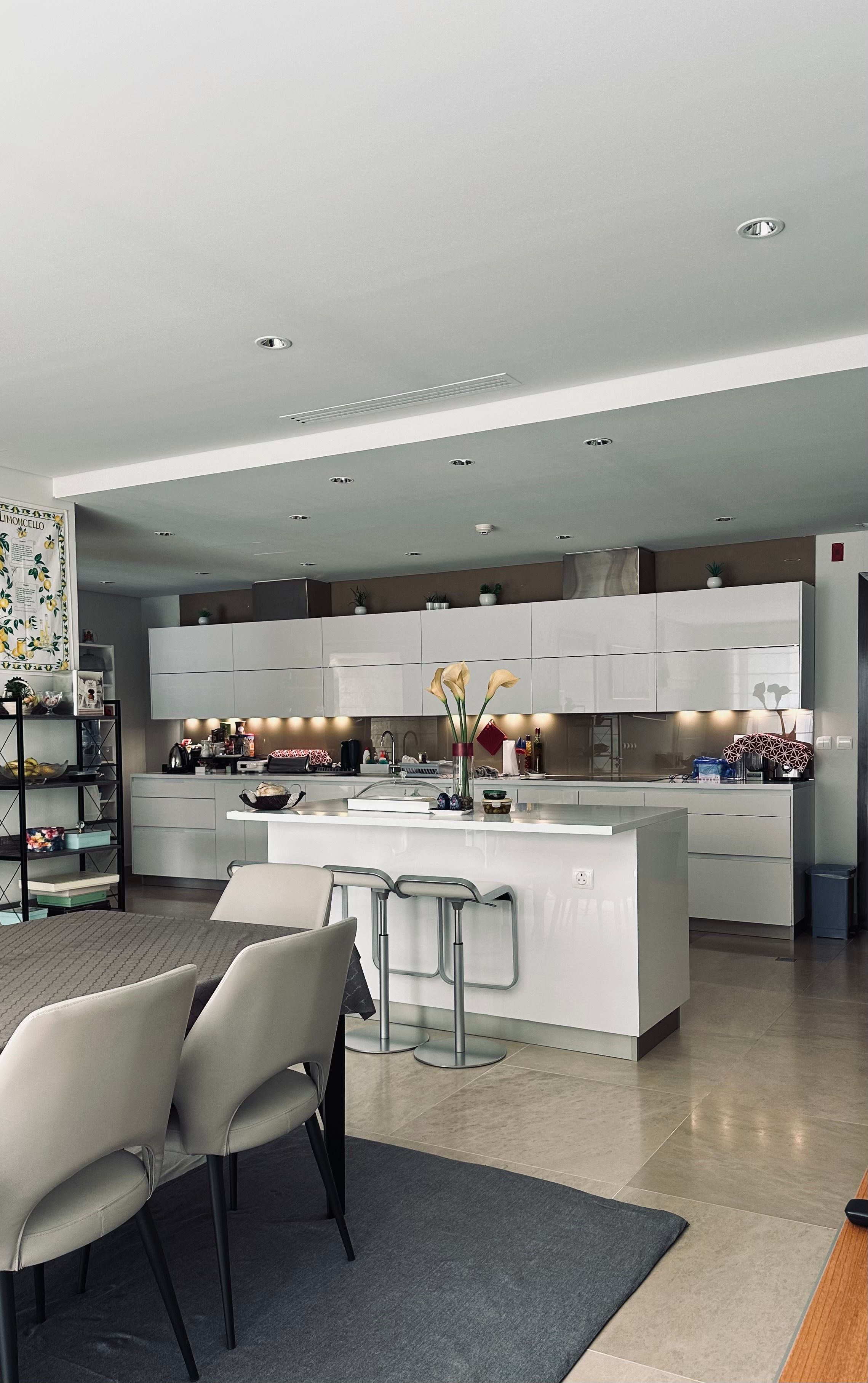 Sleek modern kitchen featuring white cabinets, island, and elegant decor.